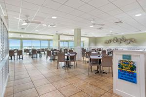 uma sala de jantar com mesas, cadeiras e janelas em Best Western on the Beach em Gulf Shores