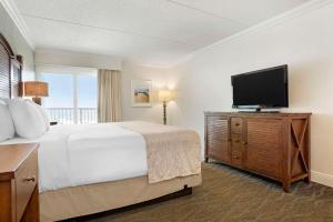 Habitación de hotel con cama y TV de pantalla plana. en Best Western on the Beach, en Gulf Shores