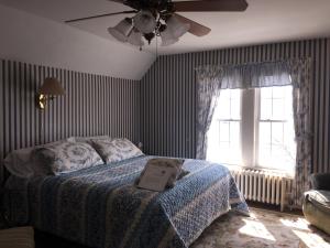 a bedroom with a bed and a ceiling fan at Harborview Inn in Gloucester