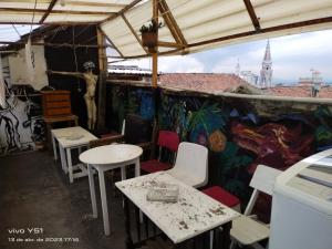 a room with tables and chairs and a wall with graffiti at Hostal Arte Candelaria in Bogotá