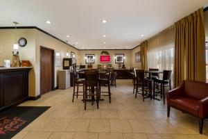 a hotel lobby with a bar and tables and chairs at Red Roof Inn Pecos in Pecos