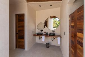 baño con espejo y puerta de madera en Casa Mava en Brisas de Zicatela