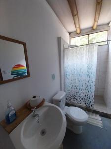 a bathroom with a sink and a toilet and a shower at Flor de bambú in Uvita