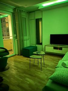 een woonkamer met een bank, een tafel en een tv bij ApartmanM&M in Banja Luka