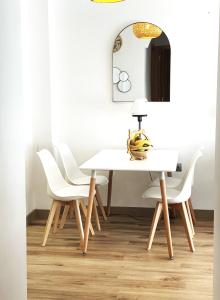 una sala da pranzo con tavolo bianco e sedie bianche di Best location for the perfect vacation a Playa de San Juan
