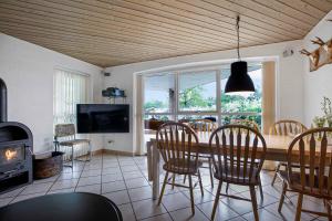 uma sala de jantar com uma mesa e cadeiras e uma lareira em Family-friendly Holiday Home Located In Quiet Surroundings em Hadsund
