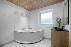 a white bathroom with a tub and a sink at Home For The Family In Quiet Surroundings in Hadsund +20 photos