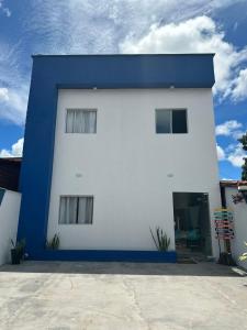 una casa bianca e blu con tetto blu di POUSADA E AGENCIA CLEDIO TURISMO a Barreirinhas