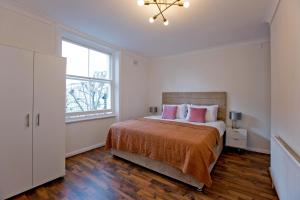 a bedroom with a large bed and a window at Marvelous Flat in Earls Court - London in London