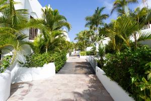 una pasarela por el patio de un complejo con palmeras en apartamento paradise luxury en Playa Paraiso