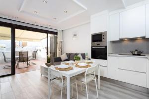 uma cozinha e sala de estar com uma mesa branca e cadeiras em apartamento paradise luxury em Playa Paraiso