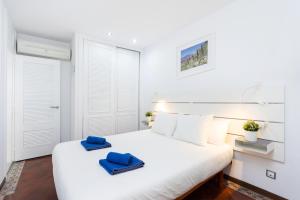 a bedroom with a large white bed with blue towels on it at apartamento paradise luxury in Playa Paraiso