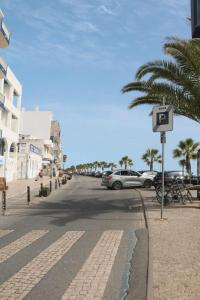 a street with cars parked on the side of the road at Coluna Mar in Quarteira +11 photos
