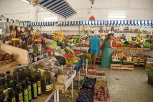 two people standing in a produce section of a market at Coluna Mar in Quarteira
