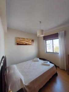 a bedroom with a bed with two towels on it at Coluna Mar in Quarteira
