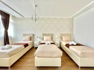 a bedroom with two beds and a chandelier at Mother Teresa Apartment in Skopje