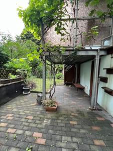 a patio with a building with a tree in it at Duisburg FeelHome, Flughafen nah,3-Schlafzimmer, Dusche ebenerdig, Zentral, WiFi, Ground Floor in Duisburg