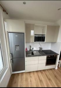 kuchnia z lodówką i zlewem w obiekcie Appartement Moderne et Chic w mieście Châtillon