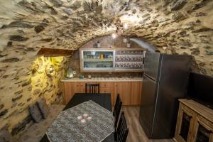 uma cozinha com uma mesa de jantar e uma parede de pedra em Sea & Mountain Serenity em Plátsa