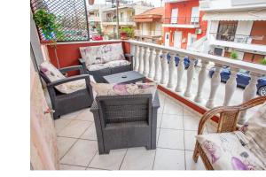 a balcony with chairs and a table on a balcony at Villa George in Nea Peramos