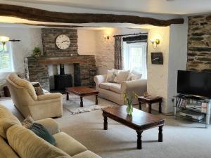 a living room with a couch and a fireplace at High Kiln Bank Cottage in Ulpha