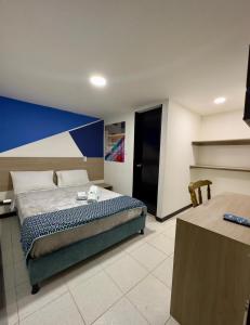 a bedroom with a bed and a blue and white wall at Hotel Santo Tomas Bogota in Bogotá
