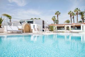 une maison avec une piscine bordée de palmiers dans l'établissement THE CLUB - Accommodation - Dining - Events, à San Miguel de Abona