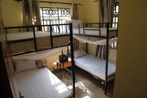 three bunk beds in a room with a window at Lovely Pearl Intercity Homes in Dar es Salaam