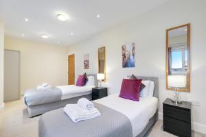 a hotel room with two beds and a mirror at Spacious Luxury 3 Bed Apt W Parking by 360Stays in Maidenhead