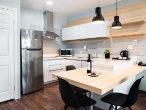 a kitchen with a wooden table and a refrigerator at Hotel Tano Guam in Tumon