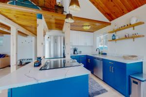 una cocina azul y blanca con techos de madera en Aquamarine Dreams, en Hoodsport
