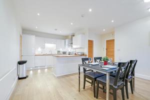 a kitchen and dining room with a table and chairs at Spacious Luxury 3 Bed Apt W Parking by 360Stays in Maidenhead