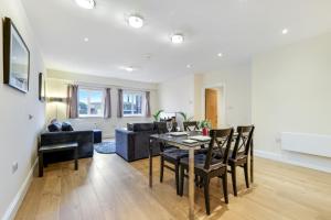 a living room with a table and a couch at Spacious Luxury 3 Bed Apt W Parking by 360Stays in Maidenhead