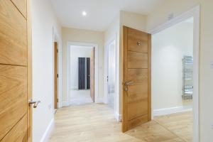 un corridoio con porta in legno in una casa di Spacious Luxury 3 Bed Apt W Parking by 360Stays a Maidenhead