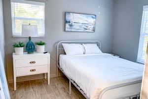 a bedroom with a bed and a nightstand with a white bed at Sea Pine Cottage in St. George Island