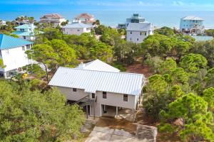 uma vista aérea de uma casa branca numa colina com casas em Sea Pine Cottage em St. George Island