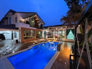 a house with a swimming pool in front of a house at The Viista Retreat 6 Bedrooms with Private Pool in Johor Bahru