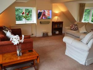 uma sala de estar com dois sofás e uma televisão em Meadowcroft No 7 em Bowness-on-Windermere