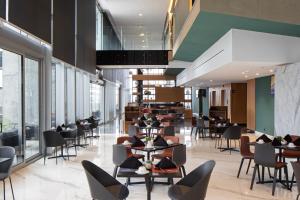 un restaurant avec des tables, des chaises et des fenêtres dans l'établissement Galeria Plaza Monterrey, à Monterrey