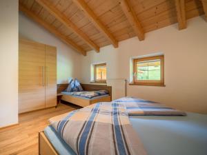 ein Schlafzimmer mit einem großen Bett in einem Zimmer mit Holzdecken in der Unterkunft Sommerstein in Maria Alm am Steinernen Meer