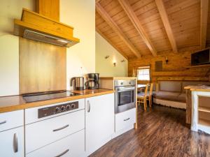 a kitchen with white cabinets and a stove top oven at Sommerstein in Maria Alm am Steinernen Meer