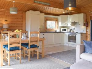 a kitchen and dining room with a table and chairs at Cwm Gain in Llanrian