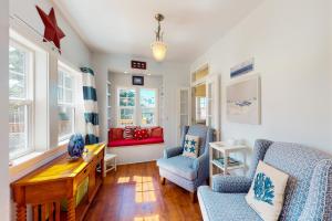 a living room with two blue chairs and a red couch at WindRose in Lincoln City