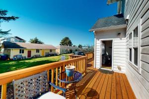 a wooden deck with a table on a house at WindRose in Lincoln City