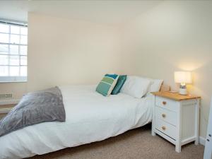 a bedroom with a white bed and a night stand at Bridgetown in Totnes