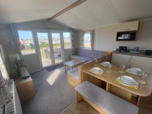a living room with a table and a couch at Cosy holiday home at Romney Sands in New Romney
