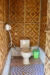 ein Bad mit einem WC in einer Ziegelwand in der Unterkunft Bohol Hammock Hostel in Batuan