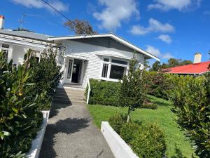 a white house with a pathway in front of it at Bayswater Homestay in Auckland