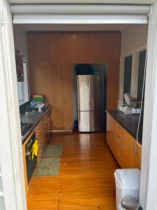 uma cozinha com um frigorífico de aço inoxidável e armários de madeira em Bayswater Homestay em Auckland