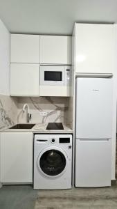 a white kitchen with a washing machine and a refrigerator at Barcelona Beach Studio in Barcelona